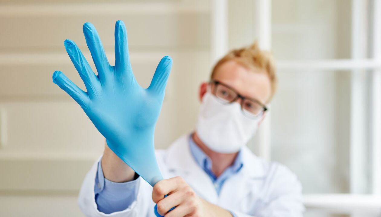 ārsts uzvelk cimdu masāžai, lai novērstu prostatītu